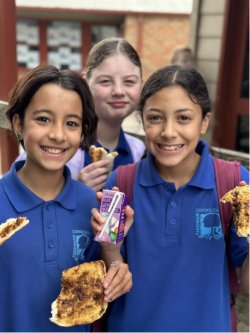 Three students having toast at a School Breakfast Clubs program